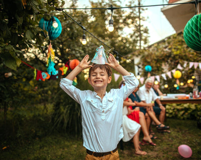 A boy in a party hat celebrating his 10th birthday.