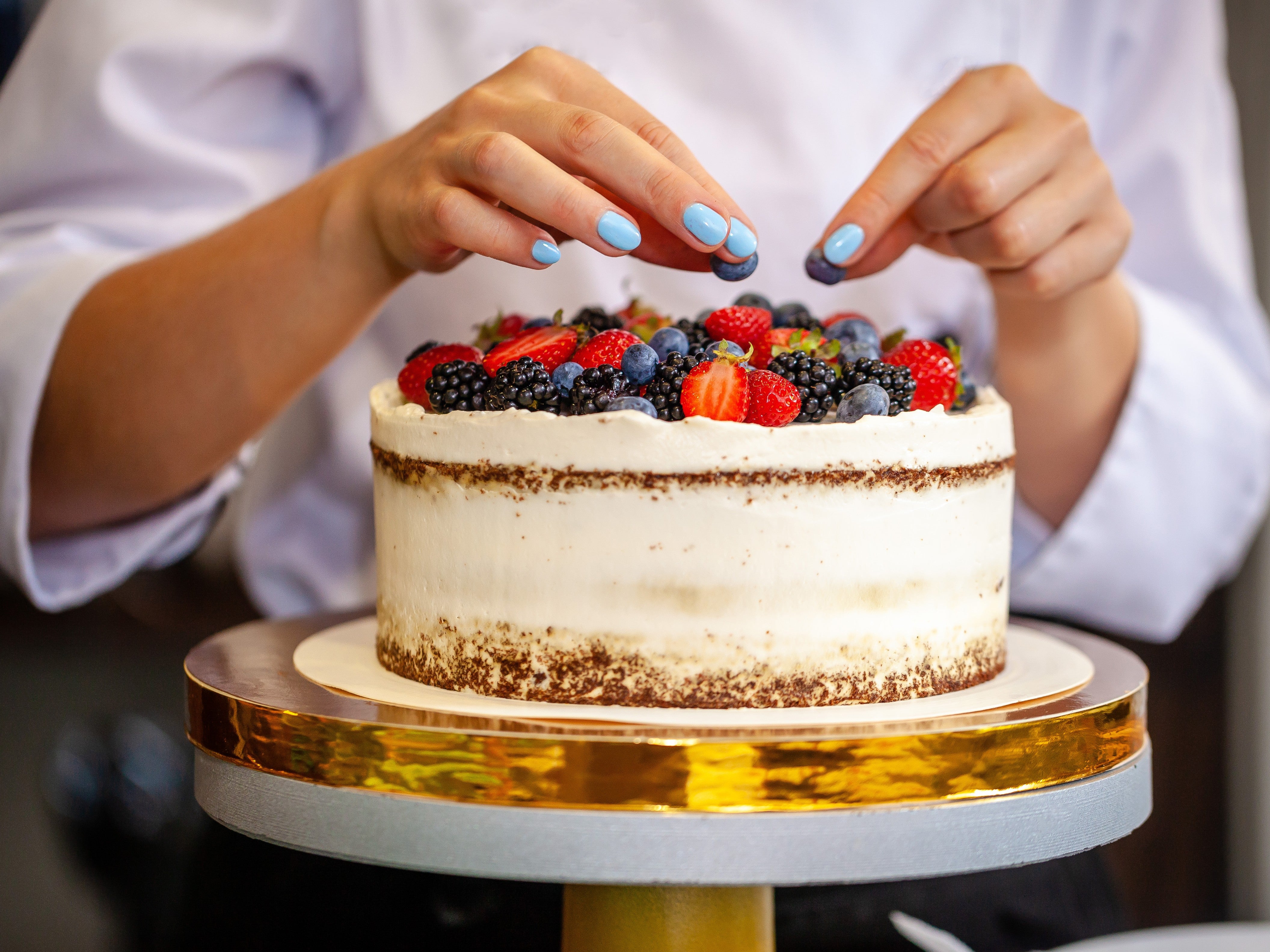 Pretty Cake Box with chef doing her final decor