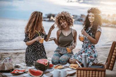 Three girls having picnic by the beach