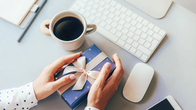 Woman holding Kris Kringle gift in the office