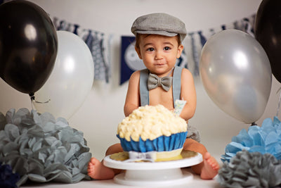 Boy celebrating 1st birthday with smash cake